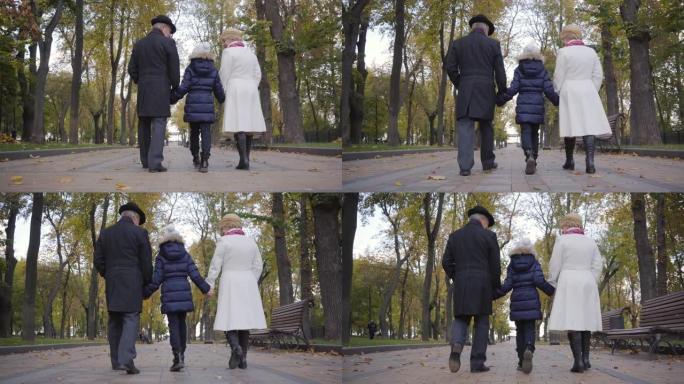 一对高加索高级夫妇与一个戴着白帽子的女孩沿着小巷散步的背景图