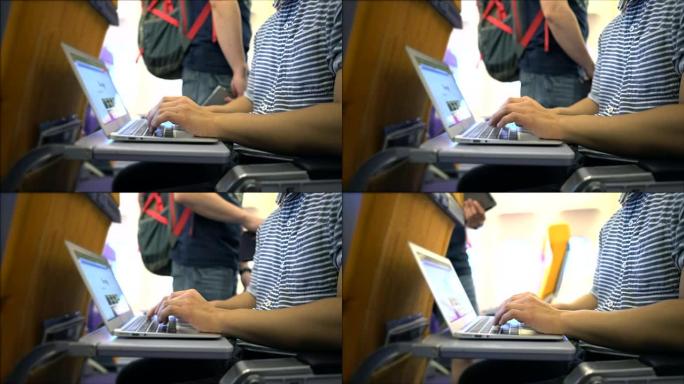 年轻人正在飞机上的笔记本电脑上工作