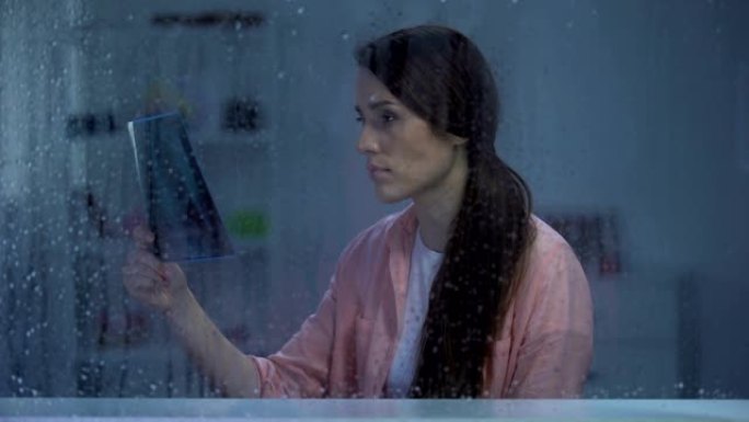 沮丧的女人在雨天看肺部x光，不治之症，癌症