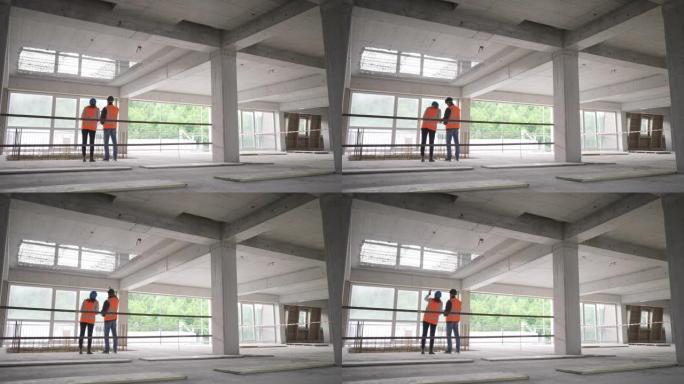 LD女服务员和男建筑师站在大楼里，一边聊天，一边检查施工细节