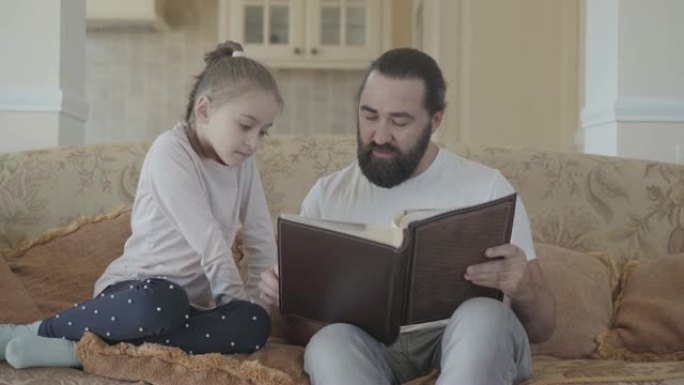 女儿和父亲的肖像坐在客厅里，看着相册，有着美好的回忆和有趣的故事。