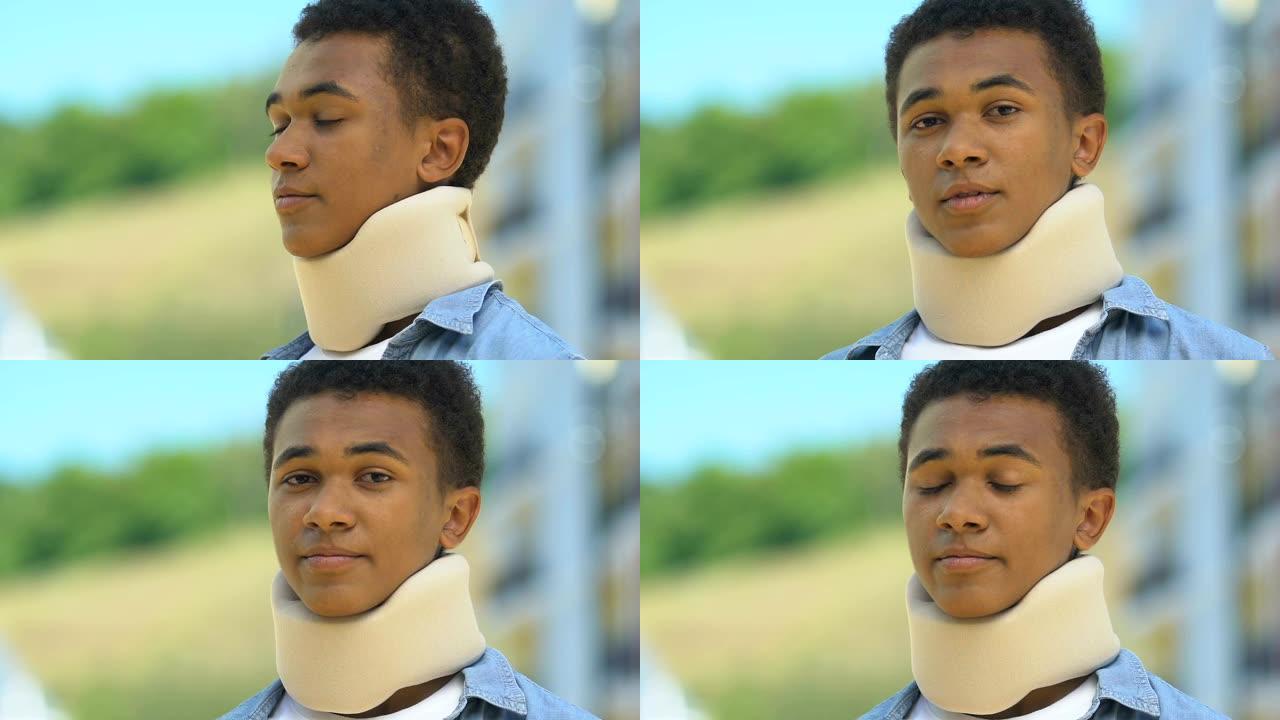 穿着泡沫颈圈的美国黑人男孩在户外看起来不舒服，颈部受伤