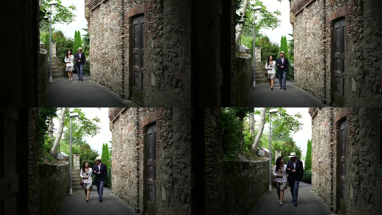 一对夫妇沿着地中海小镇的一条老街散步