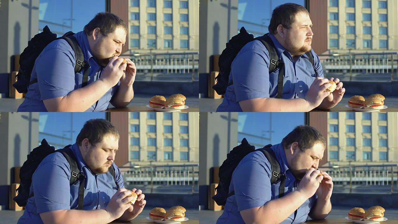超重的男性咀嚼汉堡，不健康的办公室午餐，消化问题