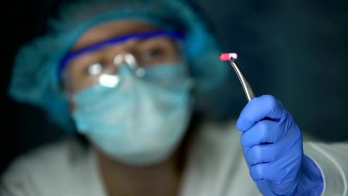 科学家在镊子中拿着胶囊，乳腺癌化疗的发展