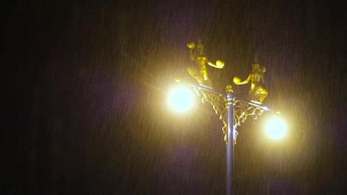 暗夜大雨中装饰在路灯上的半鸟半女人雕像