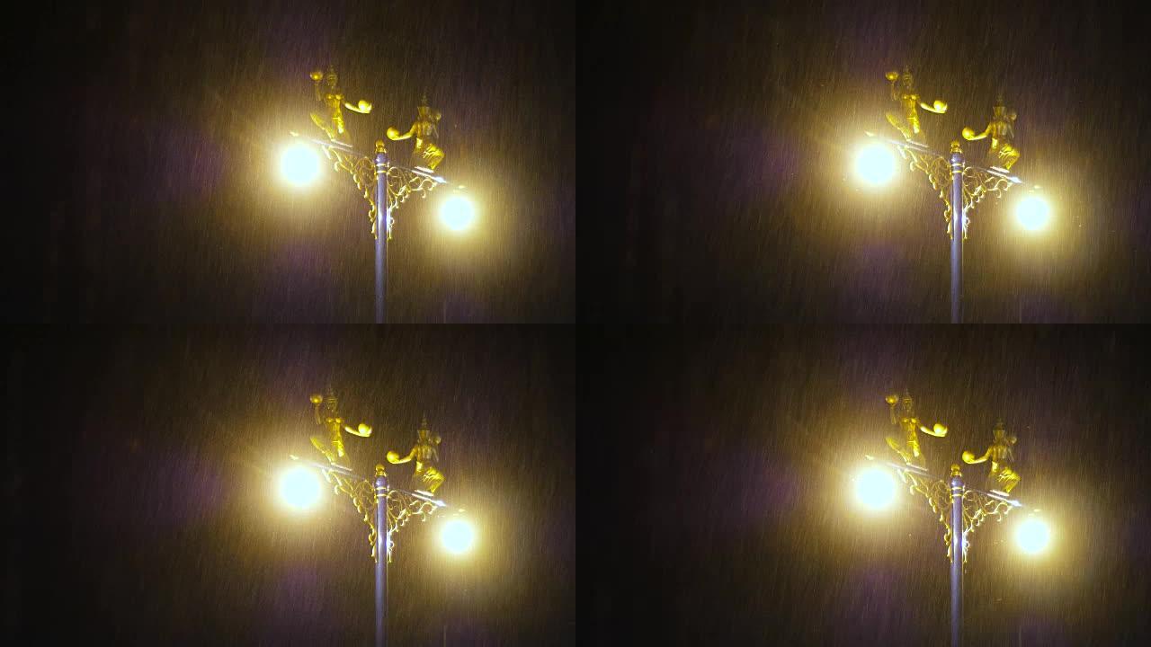 暗夜大雨中装饰在路灯上的半鸟半女人雕像