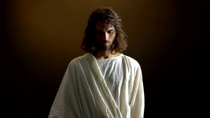 耶稣戴着荆棘冠冕，对着镜头，惩罚凡人的罪过