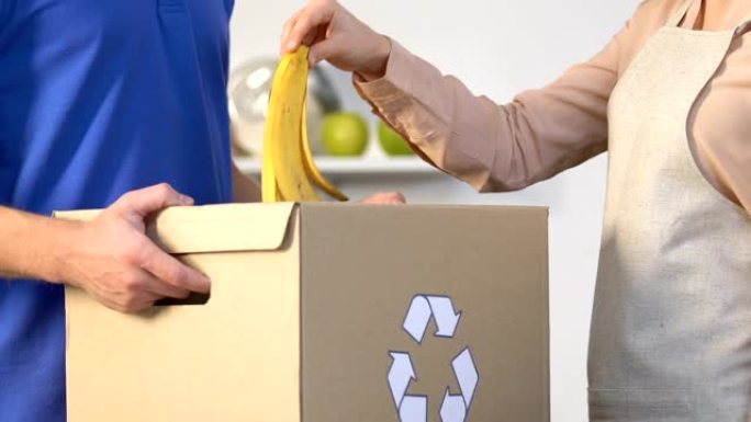 家庭主妇将香蕉皮扔进盒子里，用于有机垃圾，废物回收
