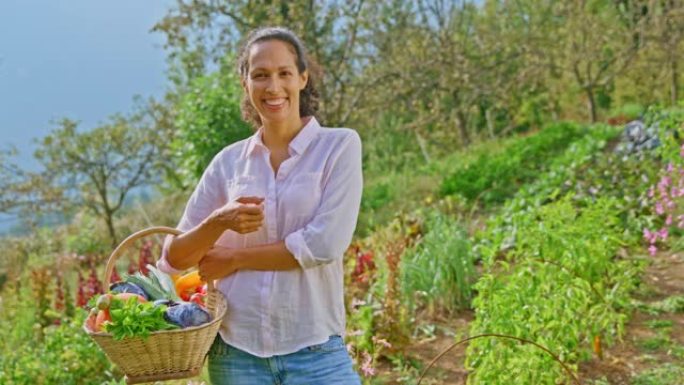 SLO MO微笑着的女性永久园艺园丁拿着装满农产品的篮子