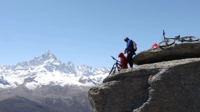 山地车手准备在垂直悬崖上猛拉 (abseil)