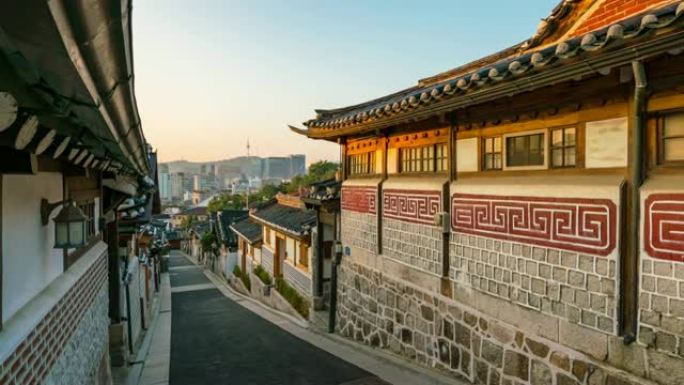在韩国首尔的南山的北村韩屋村与N首尔塔一起，在韩国首尔的背景下，延时传统的韩国风格建筑。