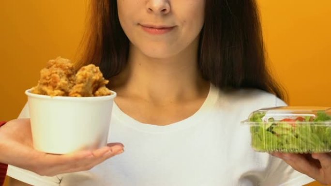开朗的女人选择绿色沙拉而不是炸鸡，健康的生活方式
