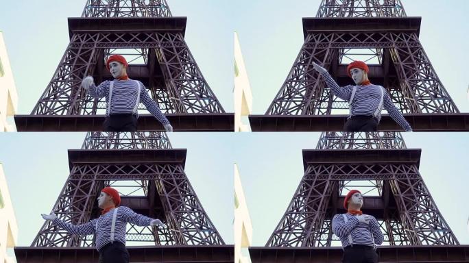 穿着红色贝雷帽和脱光衬衫的滑稽男子哑剧在埃菲尔铁塔附近玩耍