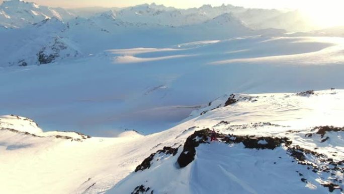 在雪山边缘拍摄滑雪者的空中垂直无人机