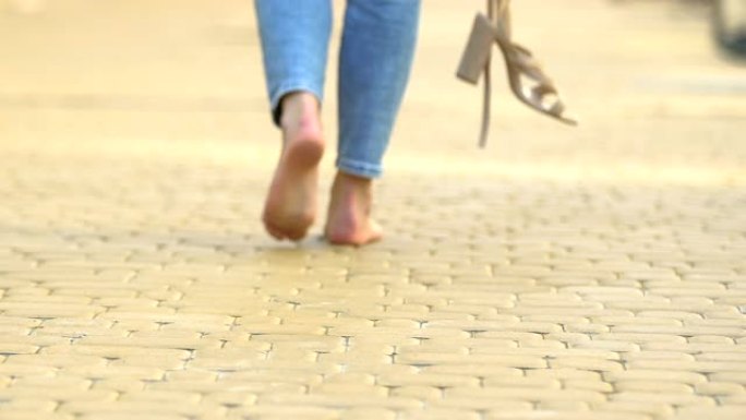 无忧无虑的女性赤脚行走高跟凉鞋，舒适自由