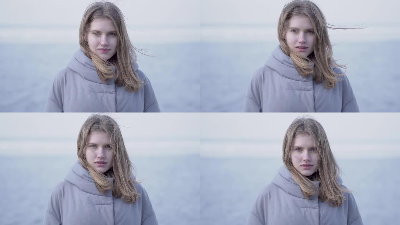 美丽的年轻金发女子的肖像，长发和蓝眼睛看着镜头。斯堪的纳维亚在冰川上的迷人女人