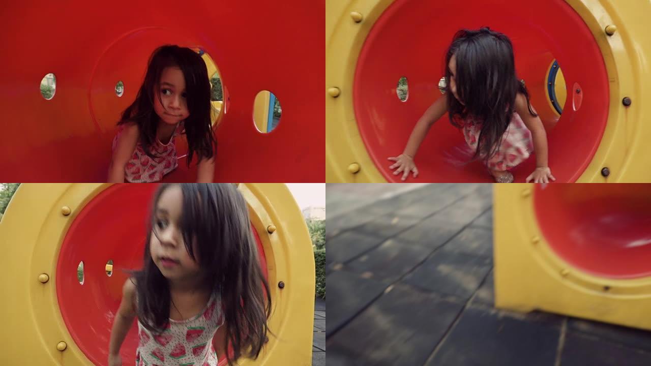 一个小女孩在操场上的红色隧道玩耍