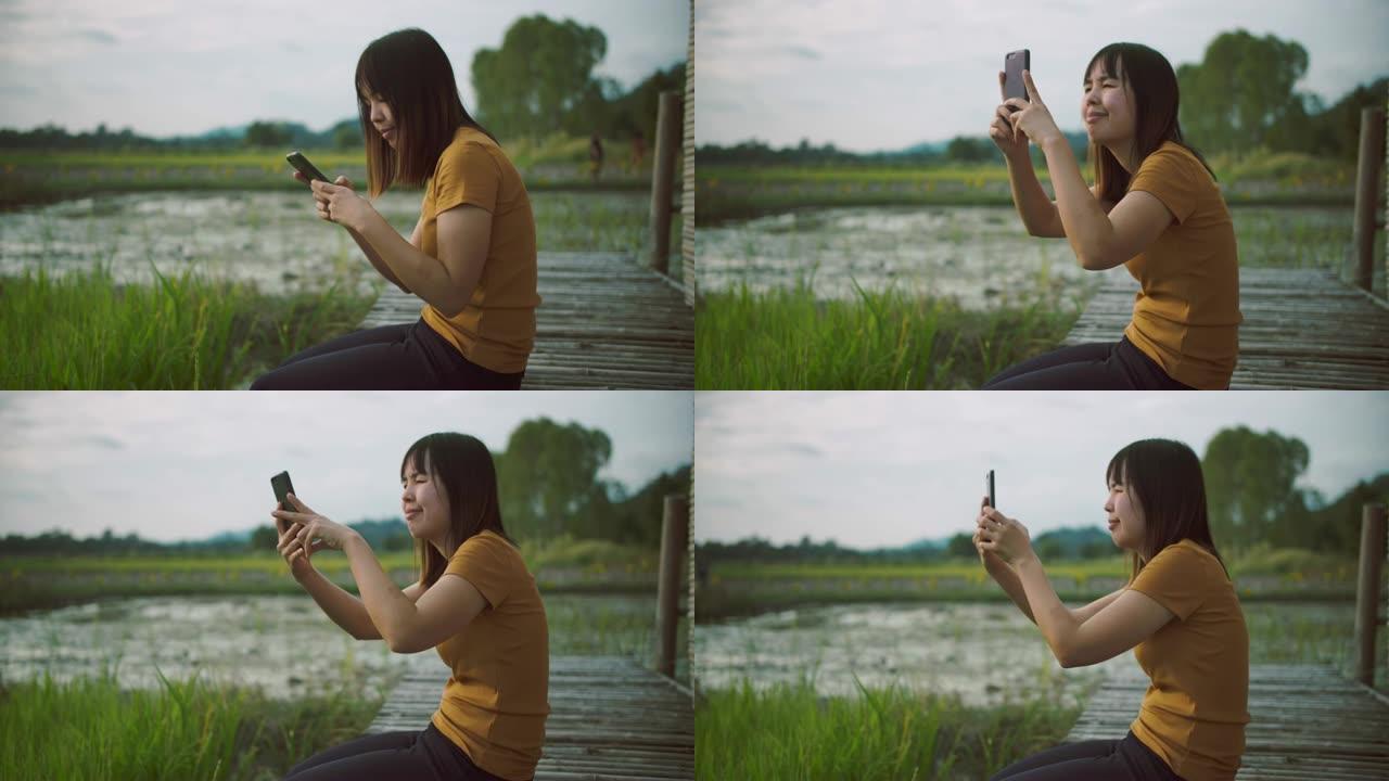 年轻女子在稻田里发短信