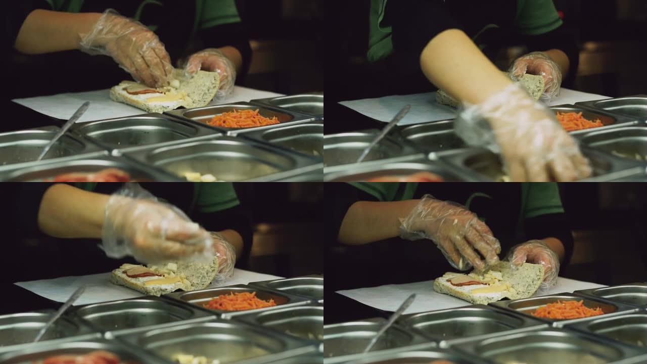 戴着一次性手套的炊具将鸡蛋放入自己动手的面包卷中，从玻璃冰箱中取出配料