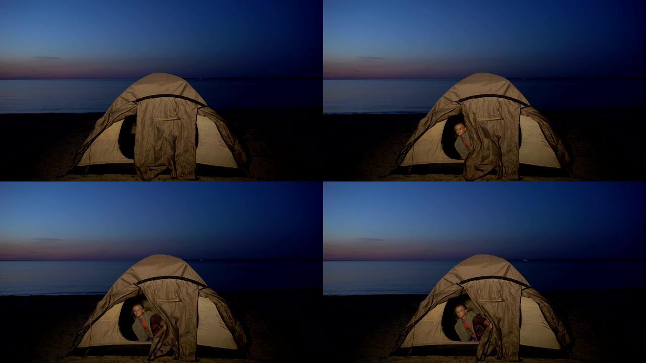 小女孩晚上躲在海边的帐篷里，无家可归的孩子们扎营，贫困