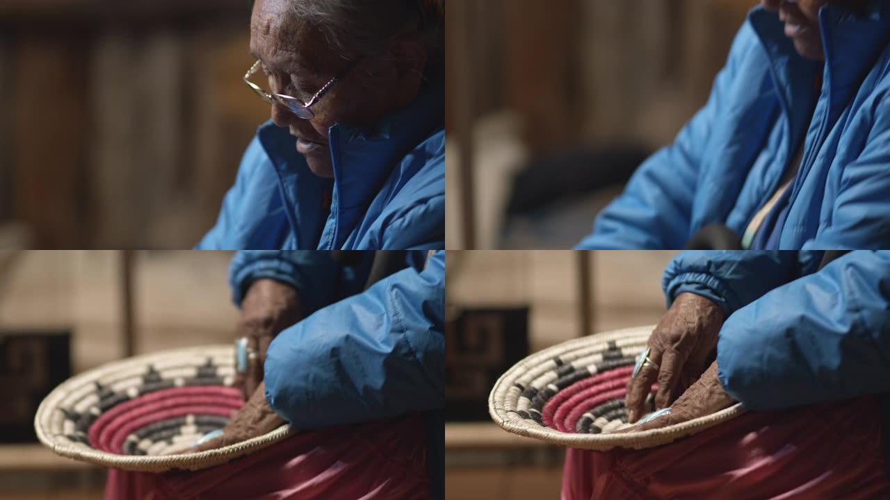 一位八十多岁的美国原住民 (纳瓦霍人) 妇女，手指上戴着绿松石戒指，抚摸并讨论了编织的纳瓦霍人篮子