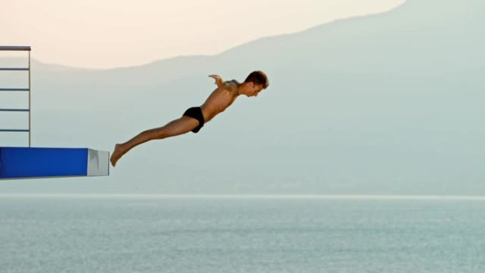 SLO MO男性高潜水员在落日比赛中跳伞