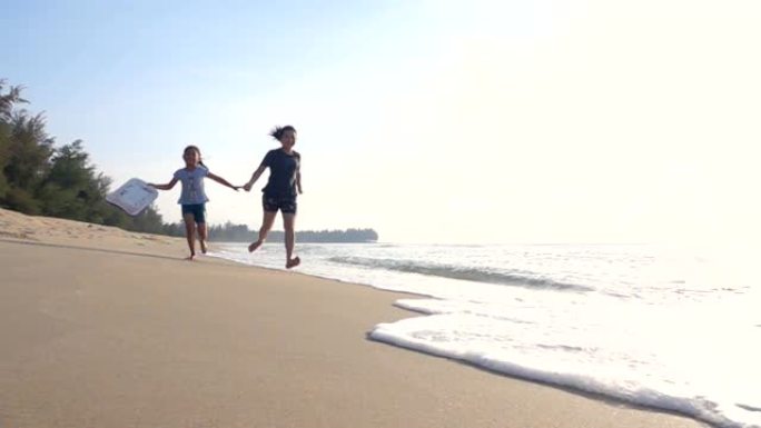 幸福的家庭，日落时的海滩上的母女，慢动作