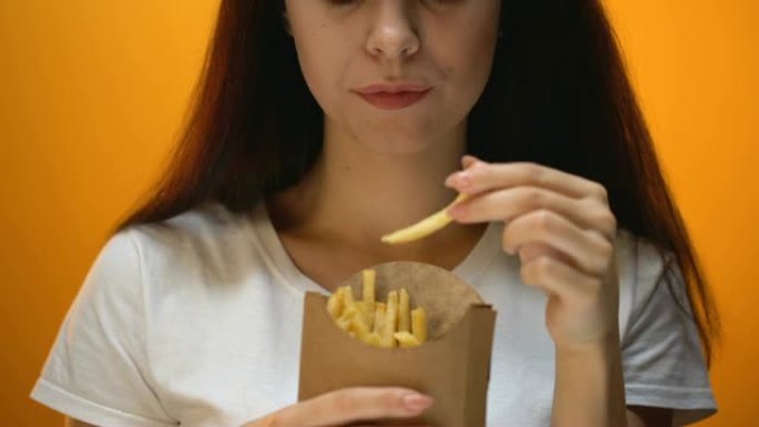 女孩吃薯条，享受快餐，高热量膳食，肥胖风险