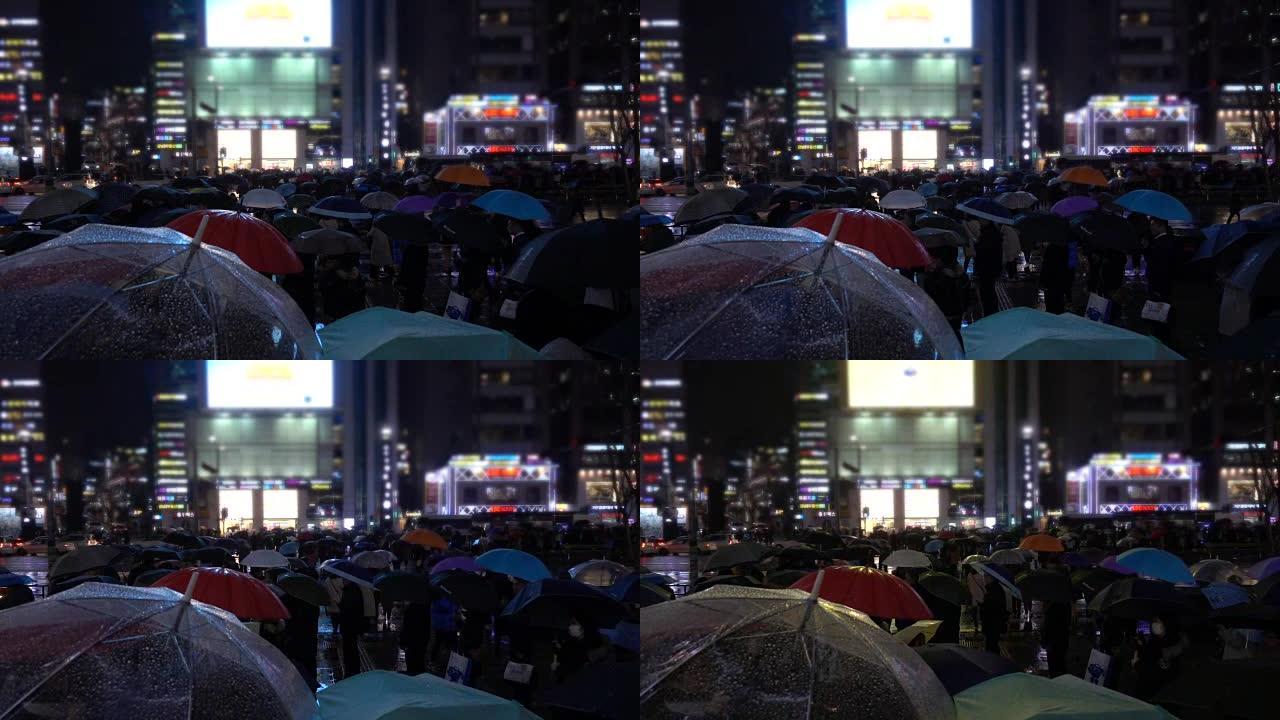 人们在不同灯光下的雨中行走在人行横道上，韩国首尔