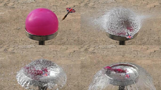 飞镖的慢动作刺穿粉红色的水球