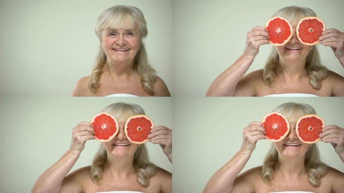 乐观的衰老女士用柚子片闭上眼睛，美容程序