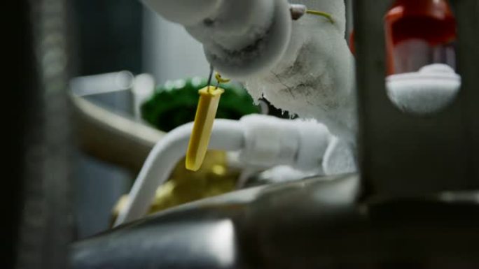 在室内制造设施中，涂有霜冻的管道连接到液氮罐