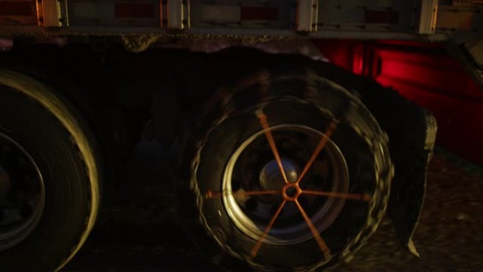 夜间配备防滑链的半卡车车轮和轮胎的侧视图