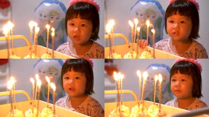小女孩在聚会上吹灭生日蛋糕上的蜡烛