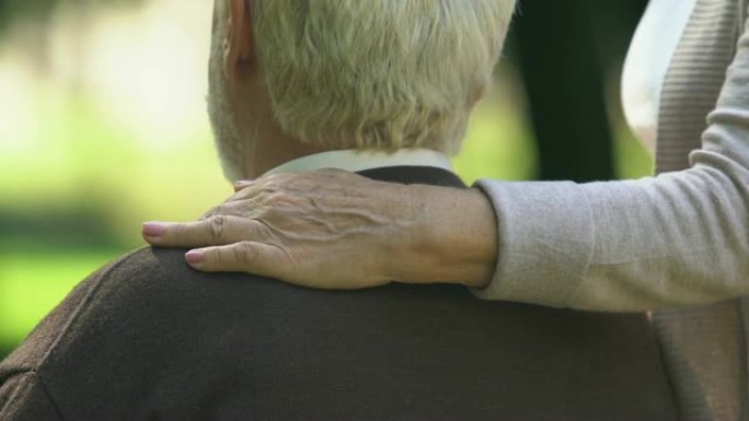 老妇人小心翼翼地拥抱丈夫坐在长凳上，建立关系，信任