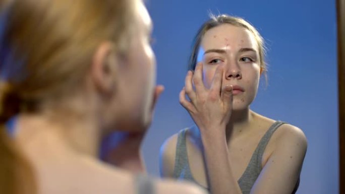 女性青少年涂抹面霜，痤疮治疗，护肤镜反射