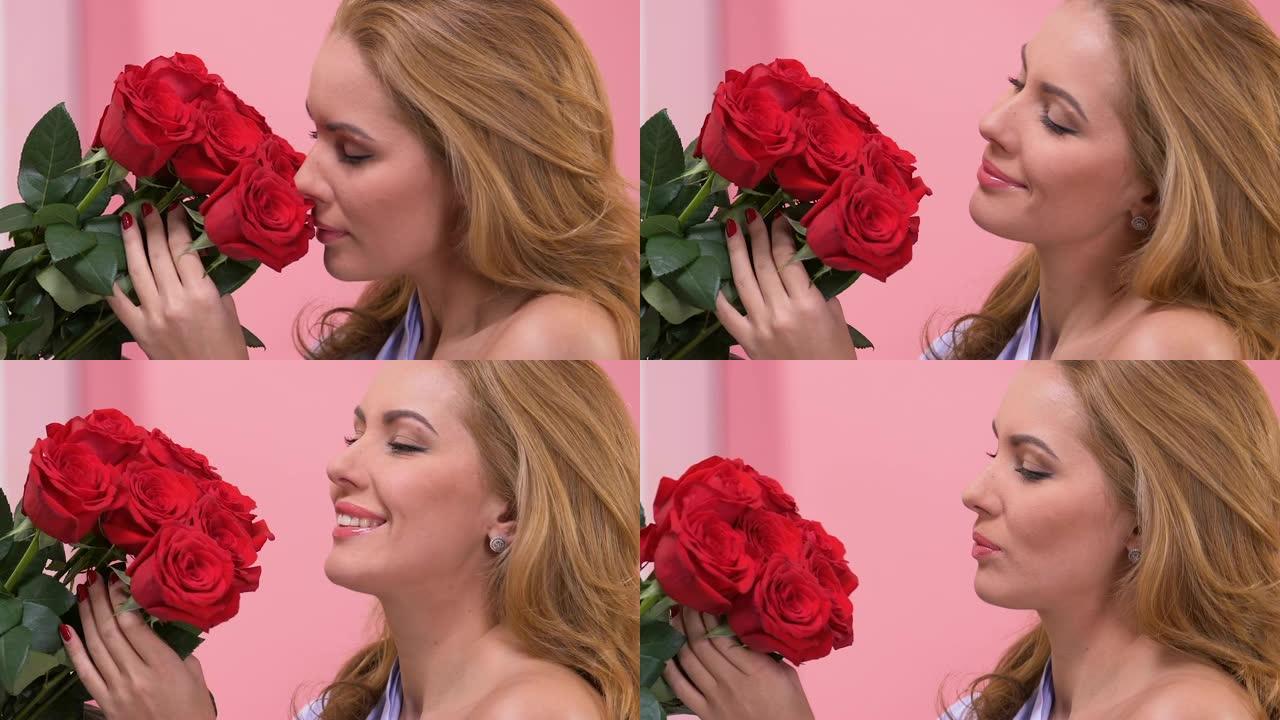 美丽的女人欣赏一束红玫瑰，情人节惊喜