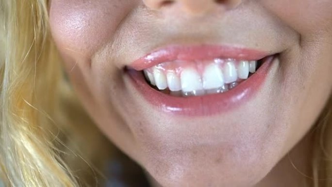 年轻女子真诚地微笑着，露出洁白的健康牙齿，牙科服务
