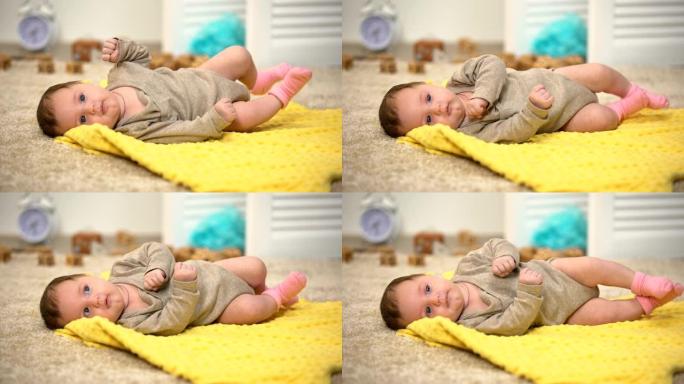 毯子上可爱的新生女婴，肌肉发育，白天活动