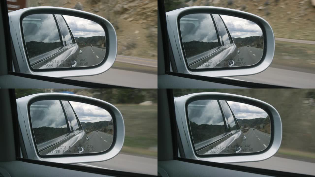 70号州际公路，汽车，科罗拉多州的落基山脉，以及在汽车侧面后视镜中反射的多云天空 (镜子中的物体比它