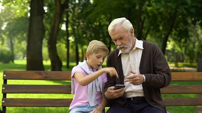 男孩教爷爷使用智能手机，养老金领取者难以获得新技术