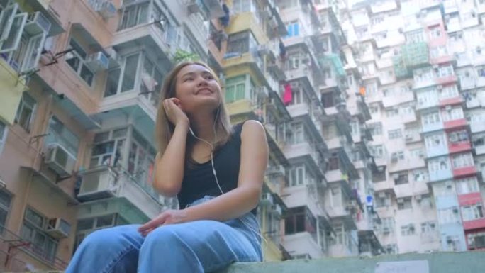 慢动作: 位于香港公寓区的听音乐女孩