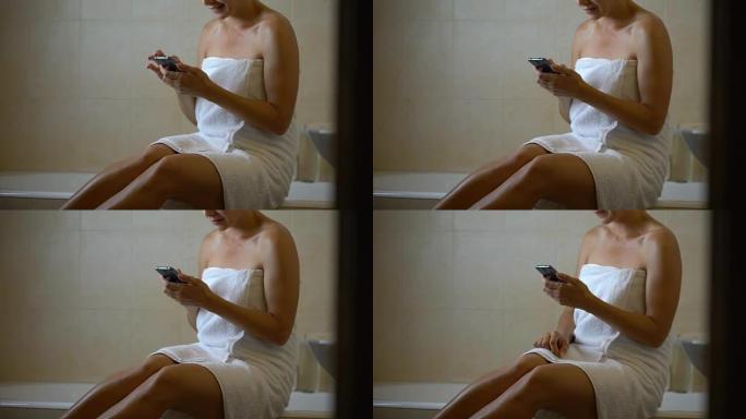 小工具上瘾的女人在浴室里使用手机，挂在智能手机上，新应用程序