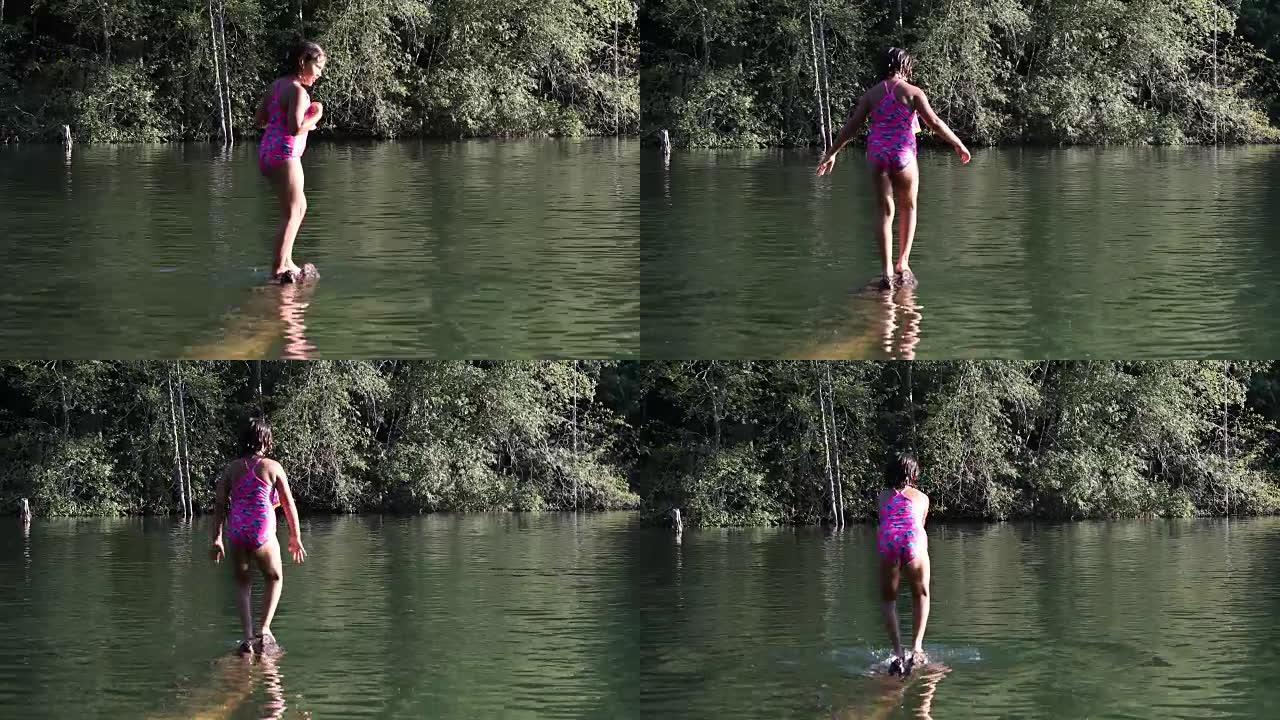 年轻的混血女孩在湖边沉没的原木上保持平衡
