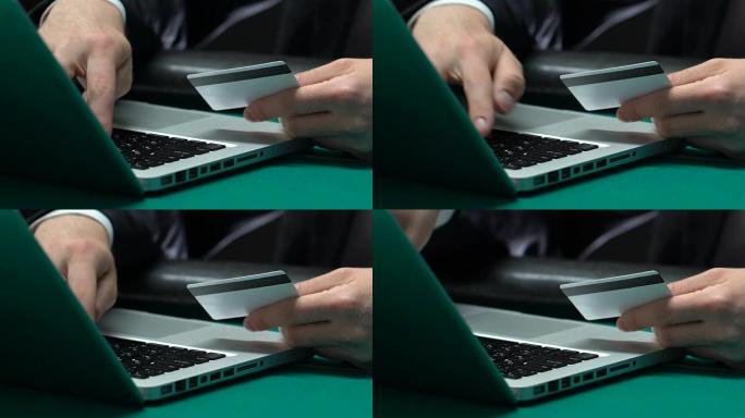 男性手在笔记本电脑上打字男子插入信用卡号，网上银行