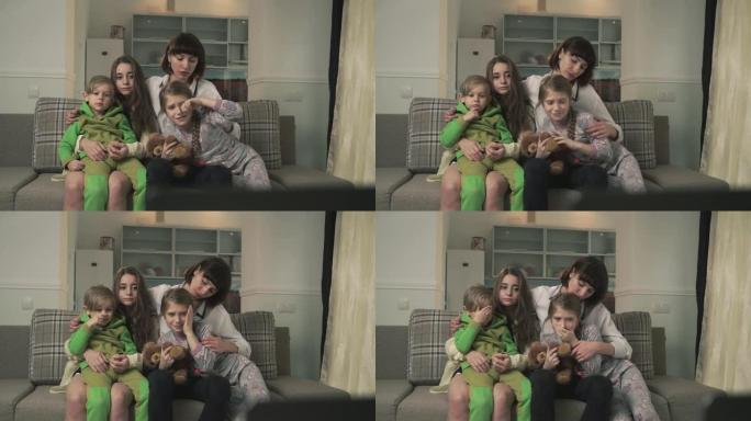 一家人坐在客房的沙发上看电视。由于屏幕上不良的不适当内容，姐姐对孩子闭上了眼睛。土著人民一起度过时光
