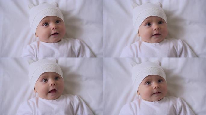 好奇的婴儿脸，穿着棉衣躺在床上的婴儿，家庭的爱与关怀