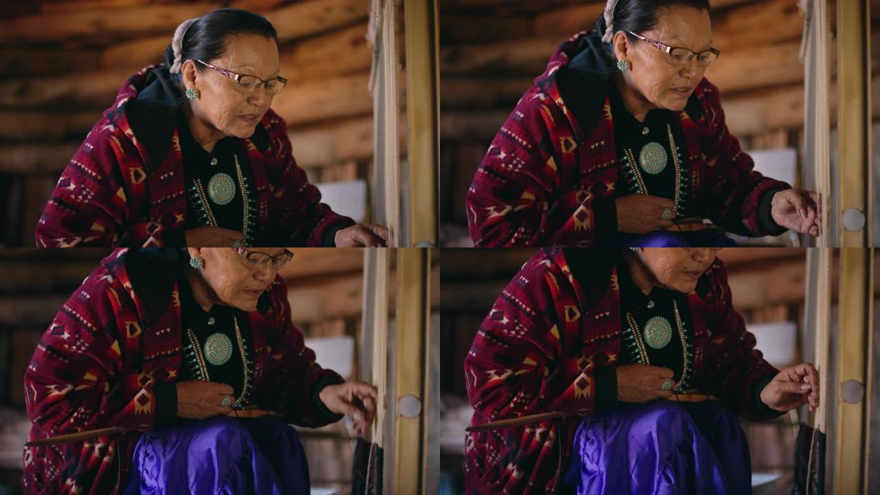 六十多岁的美国原住民妇女 (纳瓦霍人) 在霍根 (纳瓦霍人) 的室内织机上编织