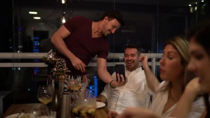 朋友在家里吃饭的时候玩得开心，用手机